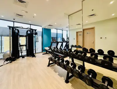 a gym with a row of treadmills and machines at Premium Guest - Dubai Riviera in Dubai