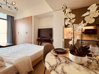 a hotel room with a bed and a table with a plant at Premium Guest - Dubai Riviera in Dubai