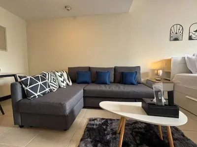 a living room with a couch and a table at Click Stay - JLT - Entire Studio & Balcony Lakes view Apartment -HW in Dubai