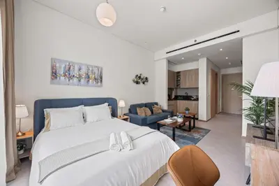a bedroom with a bed and a living room at Luxury Studio with Balcony in JVC in Dubai