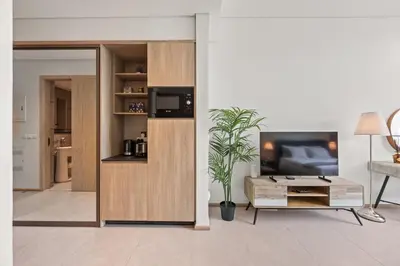a living room with a tv and a table at Luxury Studio with Balcony in JVC in Dubai