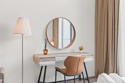 a desk with a mirror and a chair in a room at Luxury Studio with Balcony in JVC in Dubai