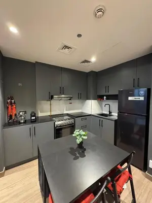 a kitchen with a black table and a black refrigerator at Peaceful Modern Home Overlooking JVC Green Park in Dubai