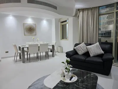 a living room with a black couch and a table at Luxury Furnished 2 BR with Stunning Sea View in Dubai