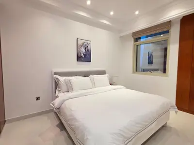 a bedroom with a large white bed with a window at Luxury Furnished 2 BR with Stunning Sea View in Dubai