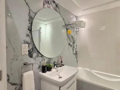 a bathroom with a sink and a mirror and a tub at Luxury Furnished 2 BR with Stunning Sea View in Dubai