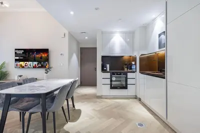 a kitchen and dining room with a table and chairs at StayMada - Ocean Heights Marina City and Sea Views in Dubai