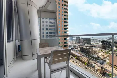 a balcony with a table and a view of a city at StayMada - Ocean Heights Marina City and Sea Views in Dubai
