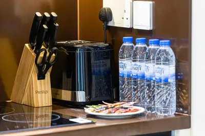 a counter top with bottles of water and a knife block at StayMada - Ocean Heights Marina City and Sea Views in Dubai