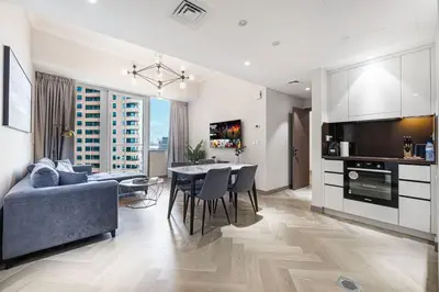 a kitchen and living room with a table and chairs at StayMada - Ocean Heights Marina City and Sea Views in Dubai