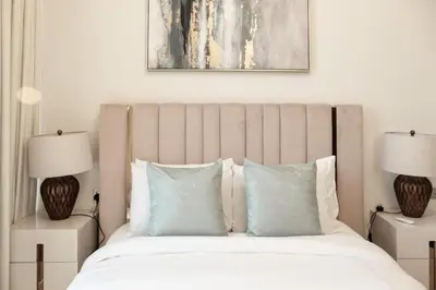 a bedroom with a large bed with blue pillows at Gemz by Danube, Private Pool, Al Furjan - Onelink in Dubai