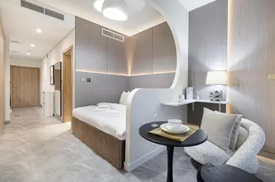 a hotel room with a bed and a table and a chair at Trendy & Brand new Studio In Business Bay in Dubai