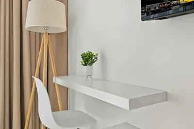 a white table and a white chair and a lamp at Estudio Pearl en Dubai by beBalmy in Dubai