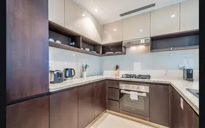 a kitchen with wooden cabinets and a stove top oven at Luxury 1025 sq feet 1 bed apartment in 29 floor Dubai Creek Residences in Dubai