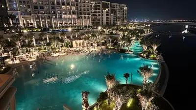 an overhead view of a large swimming pool at night at Luxury 1025 sq feet 1 bed apartment in 29 floor Dubai Creek Residences in Dubai