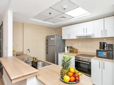 a kitchen with a bowl of fruit on a counter at Luxury Waterfront View w Ain Dubai and PS5 in JBR 5 min from the beach in Dubai