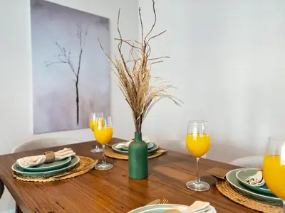 a wooden table with plates and glasses of orange juice at Luxury Waterfront View w Ain Dubai and PS5 in JBR 5 min from the beach in Dubai