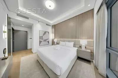 a bedroom with a large white bed and a window at Grande Tower by Emaar - Burj Khalifa and Fountain Views, Downtown Dubai in Dubai