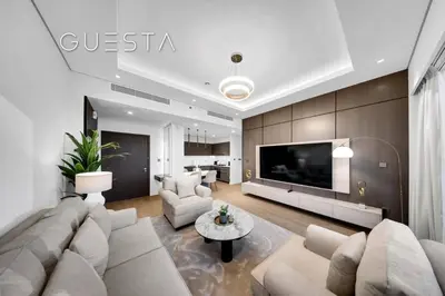a living room with a couch and a tv at Grande Tower by Emaar - Burj Khalifa and Fountain Views, Downtown Dubai in Dubai