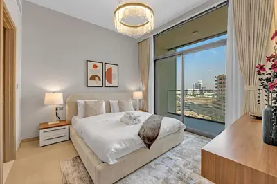 a bedroom with a large bed and a large window at Lux 1 Bedroom Apartment in Majan in Dubai