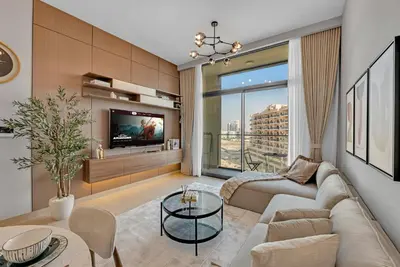 a living room with a couch and a tv at Lux 1 Bedroom Apartment in Majan in Dubai