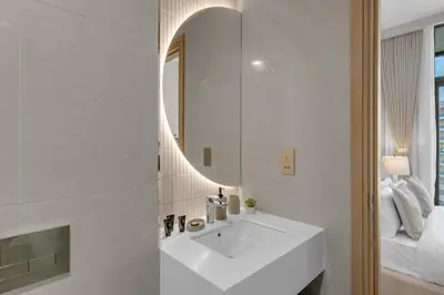 a bathroom with a white sink and a mirror at Lux 1 Bedroom Apartment in Majan in Dubai