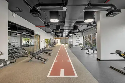 a gym with a row of treadmills and machines at Lux 1 Bedroom Apartment in Majan in Dubai