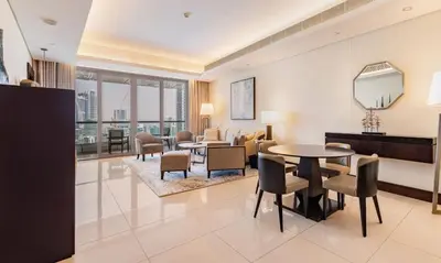 a living room with a table and chairs at Dubai Mall 5 star Free Parking in Dubai