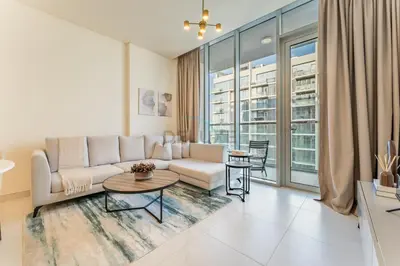 a living room with a couch and a table at Glimpse of Burj Khalifa 2BR, 15-Minute Drive to Burj Khalifa and Downtown Landmarks, District One Phase III Residences 13, Mohammed Bin Rashid Al Maktoum City by Deluxe Holiday Homes in Dubai