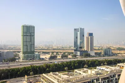 a city skyline with tall buildings and a highway at Luxury 1BR High Floor Rooftop Pool Access in Dubai