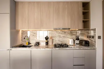 a kitchen with white cabinets and a counter top at Luxury 1BR High Floor Rooftop Pool Access in Dubai
