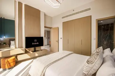 a bedroom with a large bed and a television at Luxury 1BR High Floor Rooftop Pool Access in Dubai