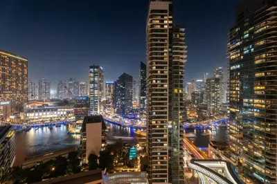 a view of a city skyline at night at GuestReady | 2BR | Stunning Canal View, JBR in Dubai