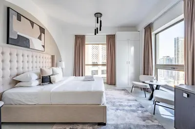 a white bedroom with a large bed and windows at GuestReady | 2BR | Stunning Canal View, JBR in Dubai