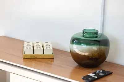 a vase sitting on a shelf next to a remote control at Luxury Marina Views Near Mall & Beach, with Gym, Swimming Pool & Car Park in Dubai