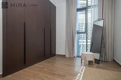 a room with a large wooden cabinet and a chair at Mira Holiday Homes - High View 2 Bed Oasis at Nobles Tower with Sauna in Dubai
