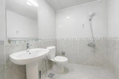 a white bathroom with a toilet and a sink at TravelTime Marina in Dubai