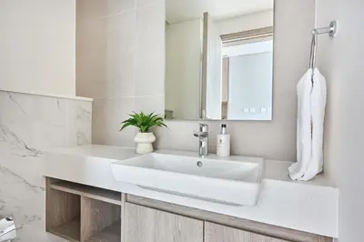 a white bathroom with a sink and a mirror at Frank Porter - Liv Marina in Dubai