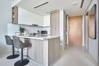 a kitchen with a counter and a bar with a chair at Frank Porter - Liv Marina in Dubai