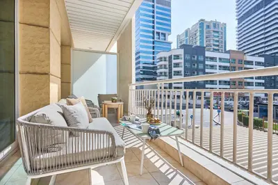 a balcony with a couch and a table at Frank Porter - Westside Marina in Dubai