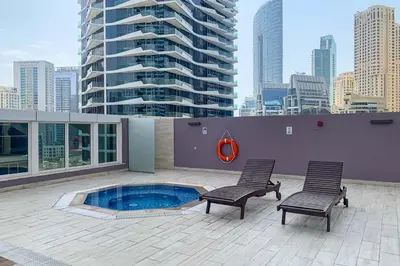 a patio with two chairs and a pool on a building at Frank Porter - Westside Marina in Dubai