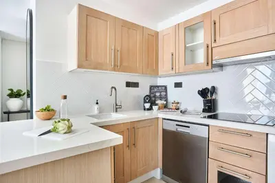 a kitchen with wooden cabinets and a sink and a dishwasher at Frank Porter - Westside Marina in Dubai