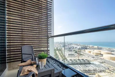 a balcony with a chair and a view of the ocean at Frank Porter - Dec Towers 1 in Dubai