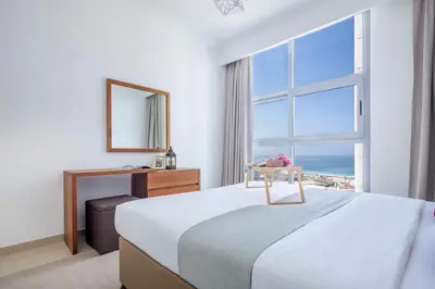 a bedroom with a bed and a large window at Frank Porter - Dec Towers 1 in Dubai