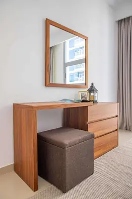 a wooden desk with a mirror and a stool at Frank Porter - Dec Towers 1 in Dubai