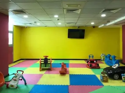 a room with a play room with toys and a yellow wall at Frank Porter - Dec Towers 1 in Dubai