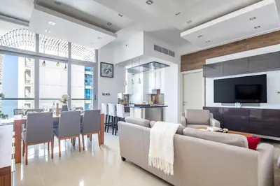 a living room with a couch and a dining room at Frank Porter - Dec Towers 1 in Dubai