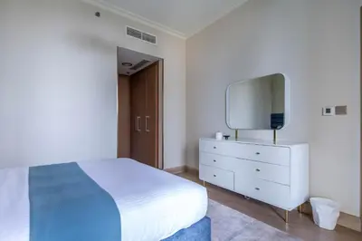 a bedroom with a bed and a dresser with a mirror at Frank Porter - Burj Vista Tower 2 in Dubai