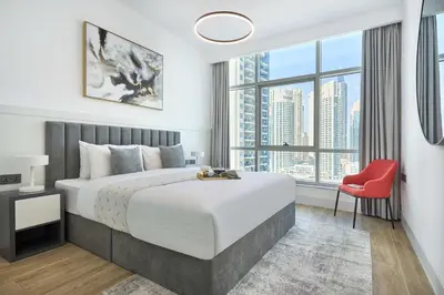 a bedroom with a large bed and a red chair at Frank Porter - Marina Diamond 4 in Dubai