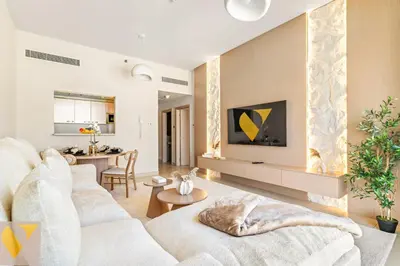 a living room with a white couch and a table at Vogue JVC Jeewar Tower Near Circle Mall, One Bedroom Apartment with Balcony and City View, Access to all Amenities in Dubai